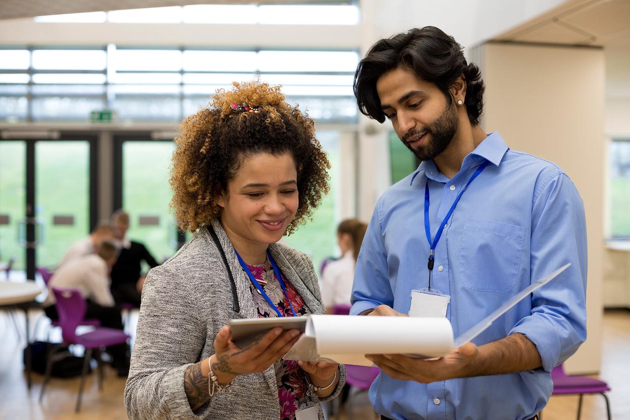 two people collaborating on a project discussing ideas with digital tablet